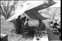 Lorna Marshall, O.P.M. Prozesky, Wilhelm Camm, and Ngani working on a list of birds in the camp tent