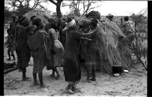 N//aba gesturing; women clapping in a circle, performing the Eland Dance
