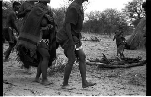 N//aba, !Xoa, and a man with eland horns walking counter-clockwise, performing the Eland Dance, seen from the ground
