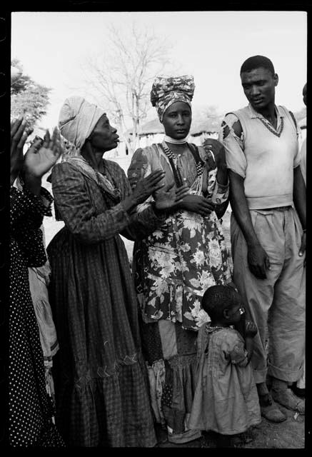 Ananias standing in a line with women who are clapping