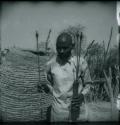 Man holding arrows with metal points and feathered ends, two of them in a quiver