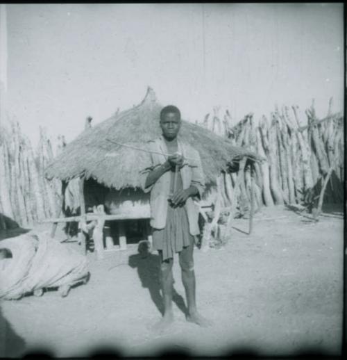 Man standing and holding a musical bow