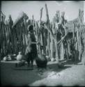 Woman stirring something in a large pottery cooking pot on the fire