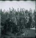 Women and children sitting and standing inside the kraal