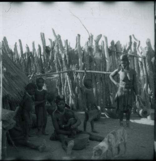 Women and children sitting and standing inside the kraal