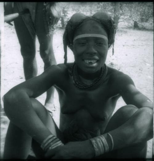 Woman sitting and showing her filed teeth