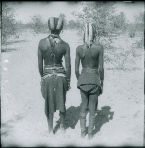 Two women standing, view of their backs