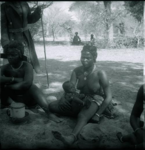 Women sitting, and one is holding a baby