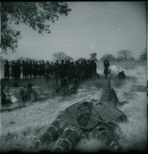 Circle of women dancing, clapping and singing, with fish traps in foreground