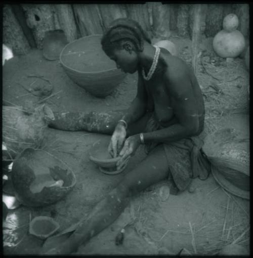 Woman sitting and making a pot