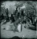 Child playing a drum, and people sitting and watching