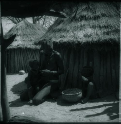 Elderly woman feeding two children