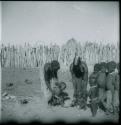 Women and children standing inside their kraal