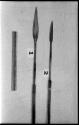 Two spear points and a ruler for measurement; one spear point is ornamented with horizontal lines