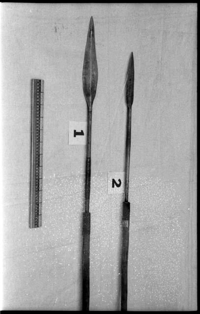 Two spear points and a ruler for measurement; one spear point is ornamented with horizontal lines