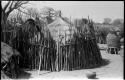 Thatched structure surrounded by pole fence