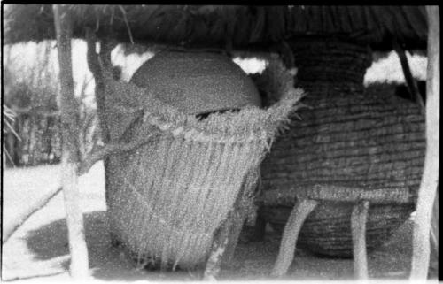 Two storage baskets under a thatched roof