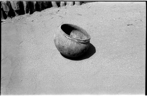 Round-bottomed pot with carrying thong around the rim; pot is ornamented with etched lines and rosettes