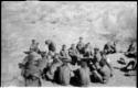 Group of seated Ju/'hoansi and Lorna Marshall (out of focus)