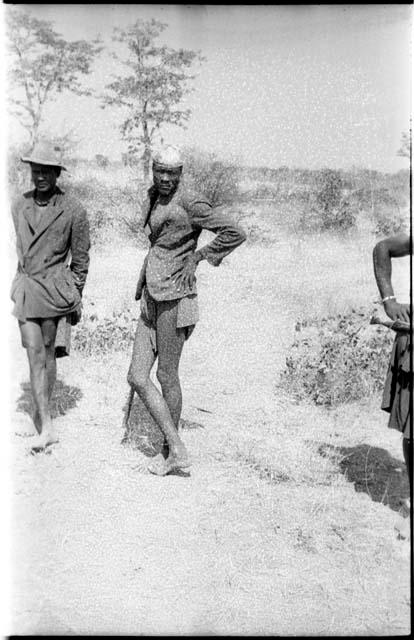 Two men, standing, wearing coats and hats