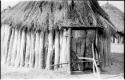 Hut in a Dimba kraal built of wooden poles and a thatched roof; the door is locked with a forked, wooden pole