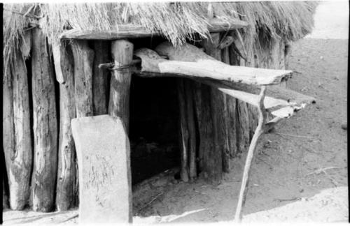 Hut in a Dimba kraal; doorway is propped up with a forked, wooden pole, close-up