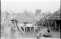 Large storage baskets in a Hinga kraal on a raised platform supported by poles and covered by a conical, thatched roof