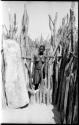 Woman standing in the opening of a fence in an Ombandia kraal