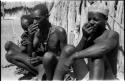 Three men sitting and taking snuff