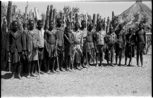 Men standing in a line including several men wearing Western clothing