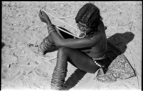 Girl sitting and playing a musical bow