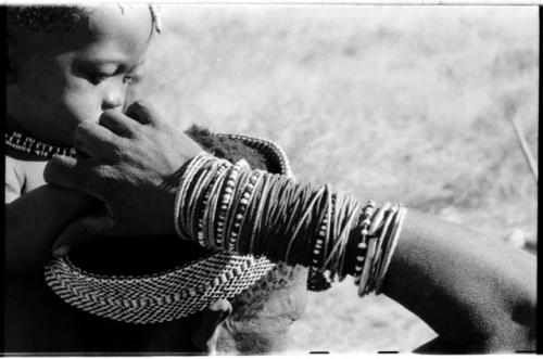 Di!ai's ("Gao Medicine's" wife) arm and head, seen from behind; a child next to her