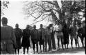 Men standing in a row, all wearing Western clothing