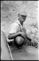 Carl Lowe, mechanic, sitting next to an expedition truck