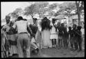 Judas Kangengi and Ananias singing in front of a line of women and boys clapping
