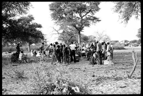 Group of people dancing and people looking on, seen from a distance