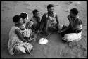 Group of young women sitting, playing a dandiri and singing