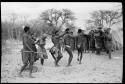 Group of people dancing; a group standing to the side