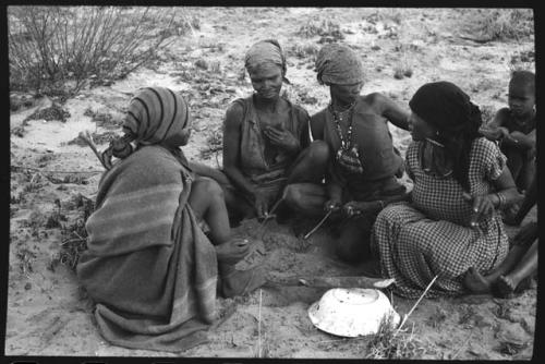 Group of women sitting and playing the dandiri