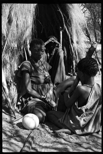 N/aoku, Nǂam n/o, and child sitting in front of a skerm