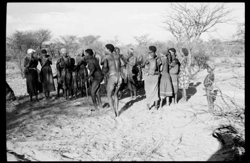 Group of men dancing, group of women clapping