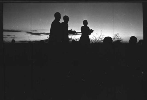 Three people in silhouette (image obscured)