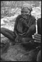 Close-up of a woman sitting and playing a dandiri
