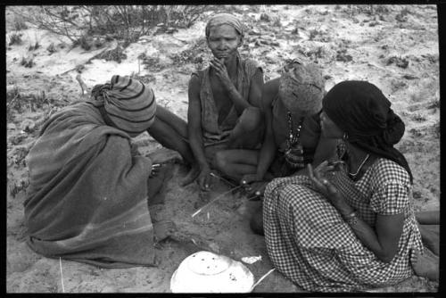 N/kxabe; Tomku; Dadum; and ǂKxoba sitting and playing a dandiri