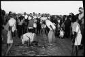 School boys playing a game; a group watching from the side