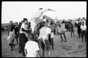 School boys playing a game; a group watching from the side
