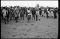 School boys playing a game; a group watching from the side