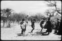 Group of people performing the Eland Dance, including three men wearing horns (copy of color slide 2001.29.8652)