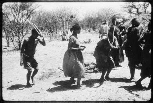 Twi, ǂKxoba and /Gaishay performing the Eland Dance, Twi and /Gaishay are wearing horns and Twi is imitating eland motions (copy of color slide 2001.29.8656)