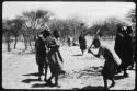 Dancers performing the Eland Dance, with Twi playing up to !Ani (copy of color slide 2001.29.8659)